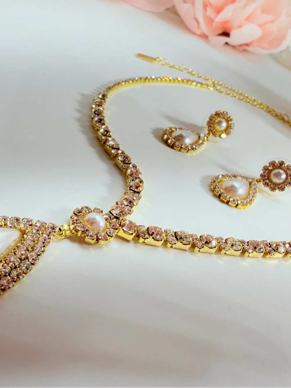 Elegant gold-tone necklace with earrings featuring a white teardrop pearl pendan